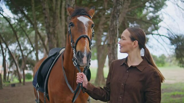 Happy girl walking equine on bridle at serene park closeup. Relaxed woman stroll