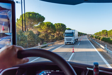View from inside a truck on a highway with cones separating the two lanes for two-way traffic, transfer.