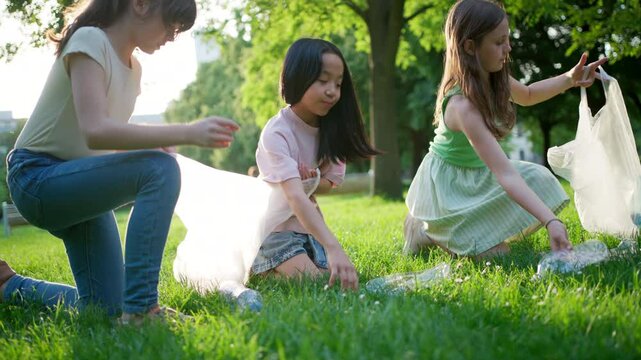 Students on nature walk picking plastic litter, environmental cleanup during outdoor sustainable education class. Concept of experiential learning and ecoliteracy.