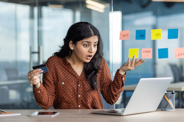 Cheated worried woman inside office, businesswoman at workplace received rejected money transfer, company worker with laptop and bank credit card in hands, error and rejection.