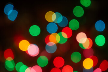 Colorful bokeh lights taken on a christmas tree. Blurred circle shapes background photography
