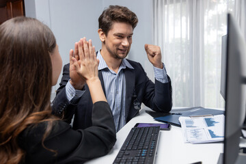 Fototapeta premium Successful in two business traders making hands high five with fist up to earn highest profit stock market in value currency online website on pc screens in real time data at modern office. Postulate.