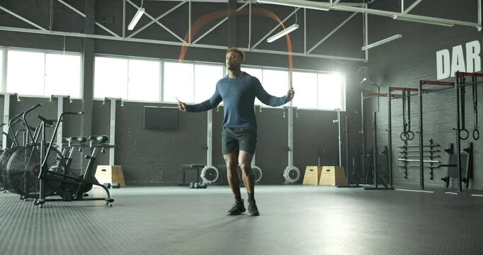 Jump, skipping rope or black man in gym for fitness for body health, training or cardio exercise in challenge. Development, agility or male African athlete with wellness, mobility workout or energy