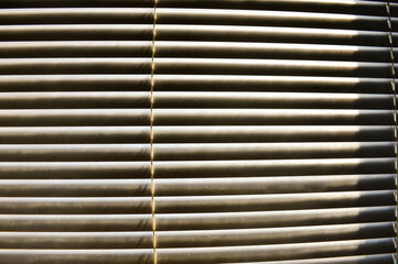 female hand with smart watch opening blinds observing sunny summer day through crack background