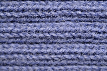 macro texture of purple crocheted sweater as a background, close-up of purple crocheted front surface, woolen texture of alpaca wool crocheted  