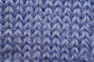 macro texture of purple crocheted sweater as a background, close-up of purple crocheted front surface, woolen texture of alpaca wool crocheted  