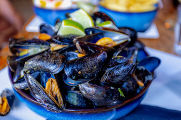 Steamed fresh zeeland mussels in a delicious white wine broth seasoned with herbs, Cooked seafood dish, Mussel is the common name used for members of several families of bivalve molluscs, Netherlands.