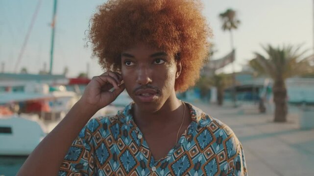 Close-up side-view portrait of young man puts on and using headphones 