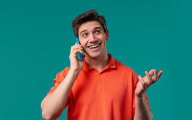 Smiling positive man talking by phone, smiling. Mature guy on blue background.