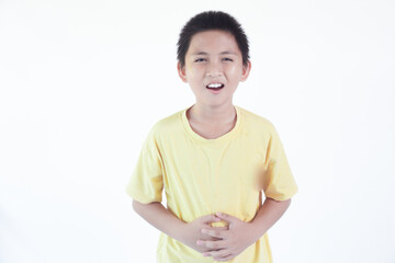 Asian little kid boy wearing yellow T-shirt standing indoor with hand on stomach because nausea, painful disease feeling unwell. Ache concept.