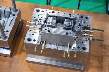 Molds for production of industrial designs. Industrial equipment on wooden table. Two metal molds....