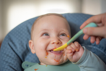 Happy 6-month-old baby starting solid foods with combo feeding