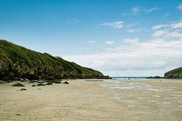 Obraz premium Tranquil Beach Scene with Lush Hills at Mawgan Porth Beach, Newquay, Cornwall
