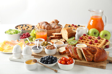 Different meals served for breakfast on white table