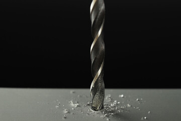 Drilling hole in grey surface on black background, closeup
