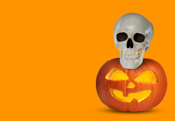 Spooky glowing jack o'lantern and scary skull on orange background, space for text. Halloween celebration