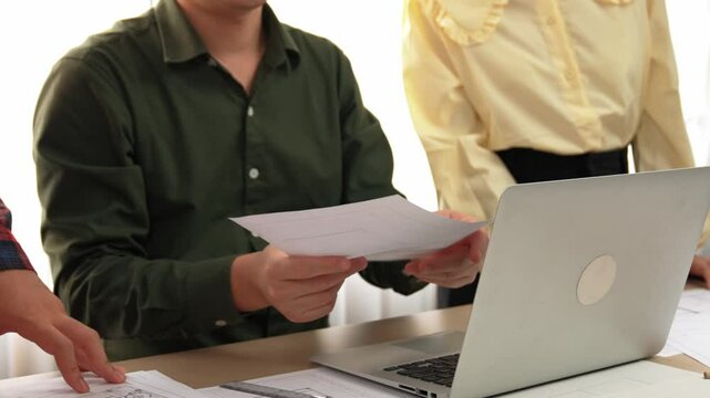 Safety engineer praising skilled architect success design building blueprint project on laptop with architectural document and measurement tool scatter around at modern office. Closeup. Delineation.
