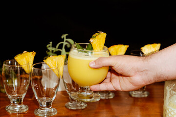 Male hands clutching a refreshing piñacolada cocktail on black background.