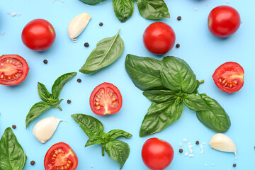 Fresh basil, cherry tomatoes and garlic on blue background