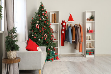 Interior of hallway with Christmas tree, sofa and coat rack