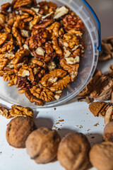 peeled and whole walnuts on a white table close up