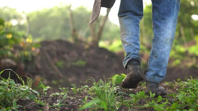 Campesino caminando con sus botas embarradas en camino de tierra