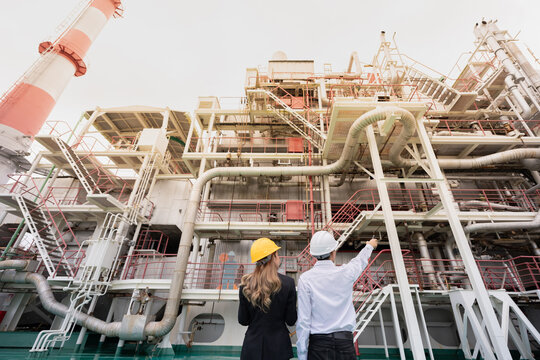 Wide-angle photograph of a nuclear power plant and its team of expert male and female engineers who are instrumental in solving energy problems and driving modern world innovations.