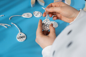 Master class word PEACE on EASTER clay egg Creator is using white air dry clay for making decor to EASTER holiday. Creating hobby recreation activity that involves fingers. DIY crafting Modern art 