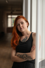 Portrait of a beautiful young red-haired girl in a studio.