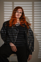 Portrait of a beautiful young red-haired girl in a studio.