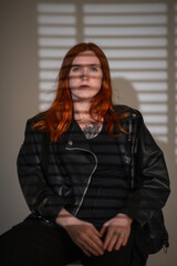 Portrait of a beautiful young red-haired girl in a studio.