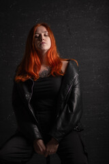 Portrait of a beautiful young red-haired girl in a studio.