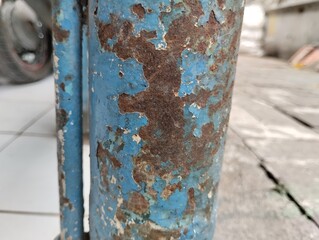 close up of blue iron paint peeling and rusty iron.