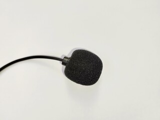 A small microphone covered with black foam on a white background