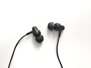 Black earphones with rubber tip covers for comfort in the ears. on a white background