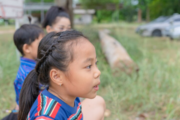 A young child stood in the park with a curious expression on his face. Her eyes widened. While staring around The girl thought deeply. and was pondering something that caught her attention.