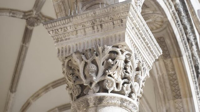 Close up of filigree worked ornamented historical medieval details on the pillars in front of the Palace Grade in Old Town Dubrovnik Croatia on a sunny summer day within the stronghold