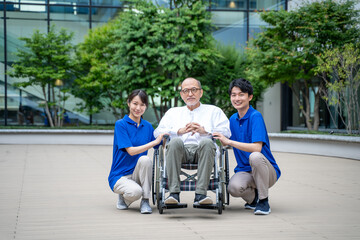 車いすのシニア男性と介護施設スタッフ