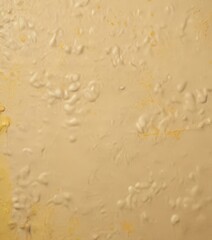 a close-up view of a textured surface with a yellowish hue, possibly a paint or coating. The surface appears to be a wall or a panel, with small bubbles or spots scattered
