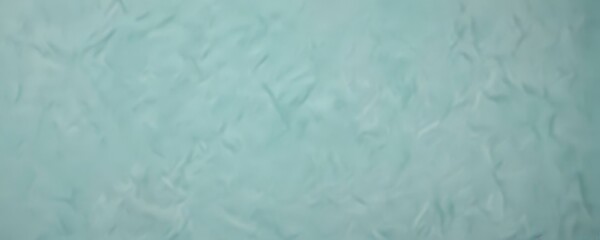 Obraz premium a blurred, textured surface in a light blue color, resembling the appearance of water or a fabric with a crumpled texture.