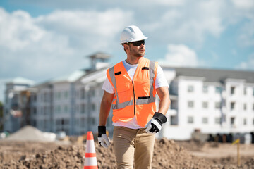 Construction site worker in helmet working outdoor. A builder in a safety hard hat at constructing...