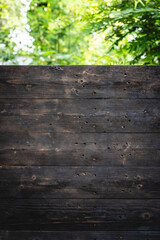 Fototapeta premium Rustic, dark wood surface aged texture showcases intricate grain patterns. Charred and weathered, planks reveal vintage, earthy warmth, creating natural, organic feel reminiscent of firewood.
