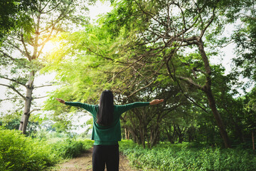 confident asian woman embraces self-love, standing peacefully in serene park at sunset. joyful...