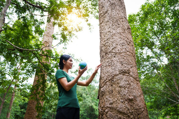 Forest conservationist holds small globe in hands, symbolizing global responsibility for protecting  planet. Standing outdoors in green park, sustainability, commitment to achieving net-zero impact.
