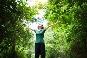 confident asian woman embraces self-love, standing peacefully in serene park at sunset. joyful...