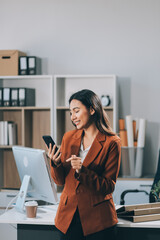 A woman is talking on her cell phone while holding a coffee cup