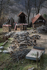 Vertical shot of piles of cut wood in a backyard in a rural area
