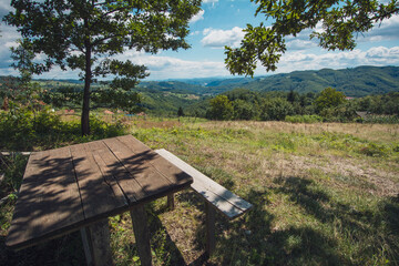 Fototapeta premium Bench on the hill with view on valley in background