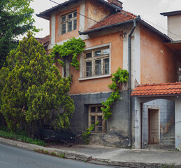 Old house in a town with ivy growing and covering facade