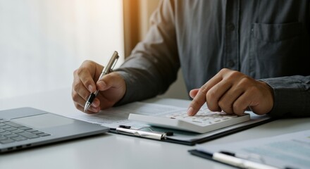 Businessman Calculating with Calculator and Pen on Documents